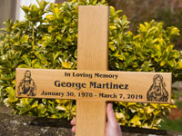 Oak memorial cross with images of Jesus and Mary.