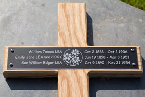 Black engraved plaque on oak cross. Black engraved plaque on oak cross.