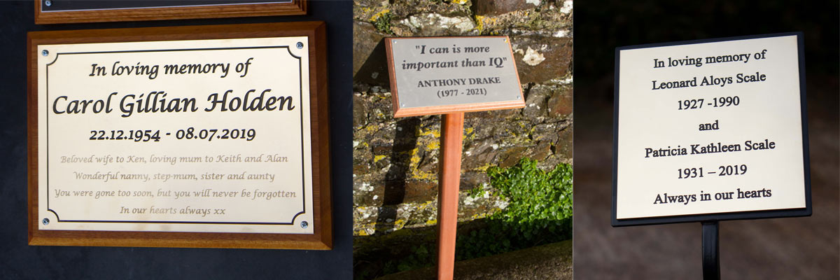 Brass plaques on wrought iron stakes or wooden backing boards.